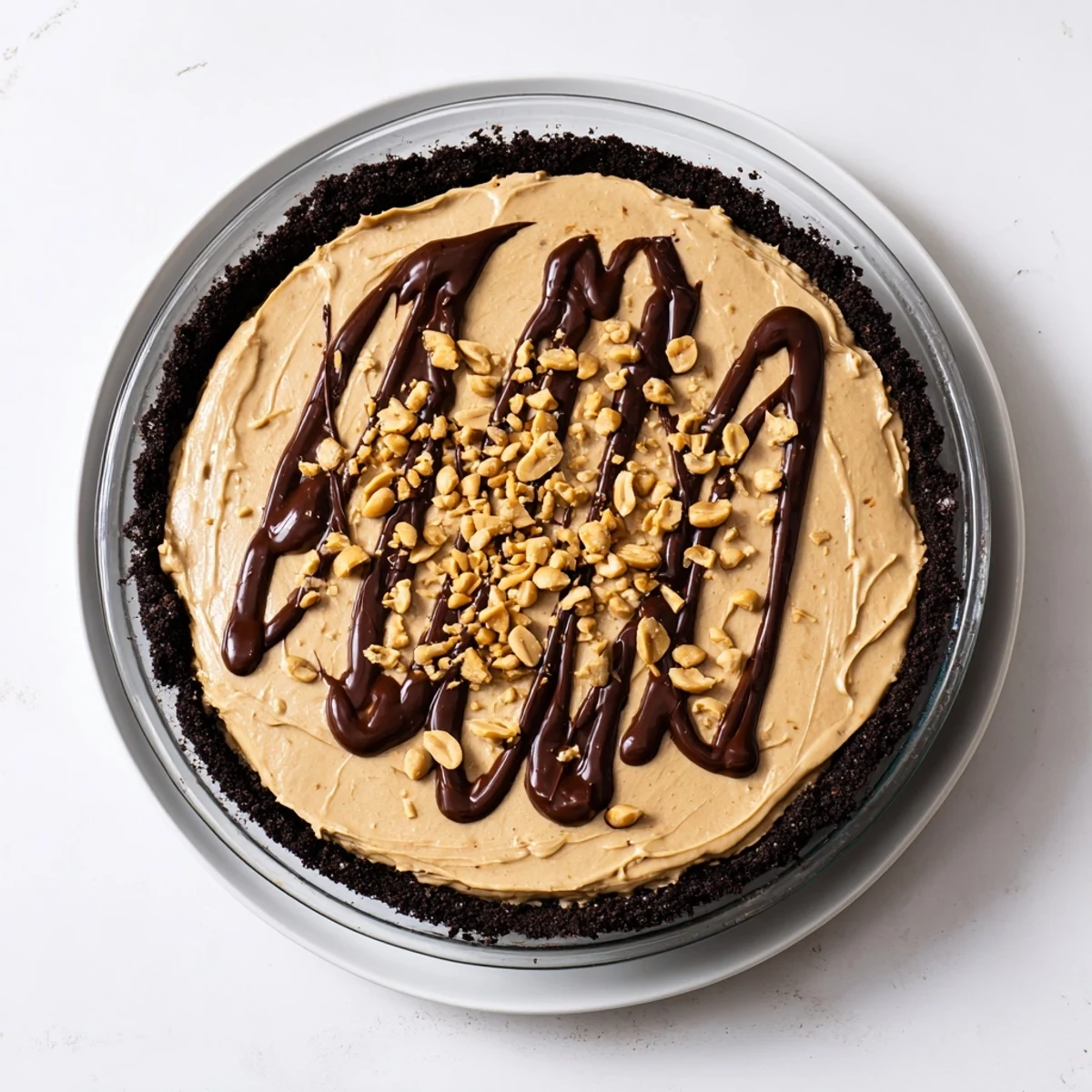 Rich peanut butter pie filling, smooth and thick, is set in a chocolate crumb pie crust.