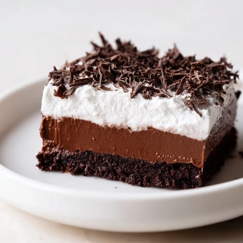 A luscious slice of Mississippi Mud Pie with layers of chocolate pudding and whipped cream.