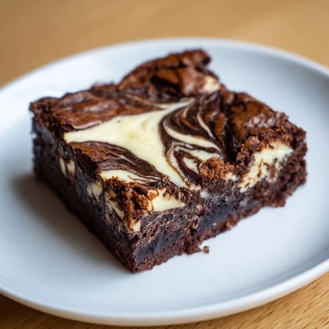 These rich cheesecake brownies have a decadent chocolate base swirled with a creamy cheesecake filling, ready to serve.