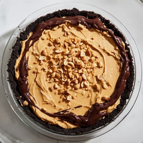Creamy peanut butter pie, a no-bake dessert, boasts a chocolate cookie crust, ready to enjoy.