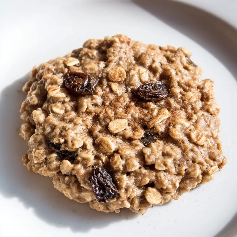 Warm, freshly baked oatmeal raisin cookies on a cooling rack, offering a classic American dessert.