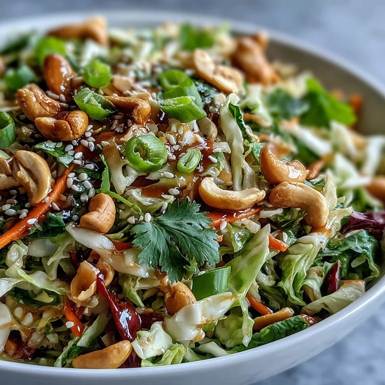 Bright Asian Cabbage Salad served in a rustic bowl, topped with chopped roasted cashews and fresh cilantro, ready for a light lunch or dinner.