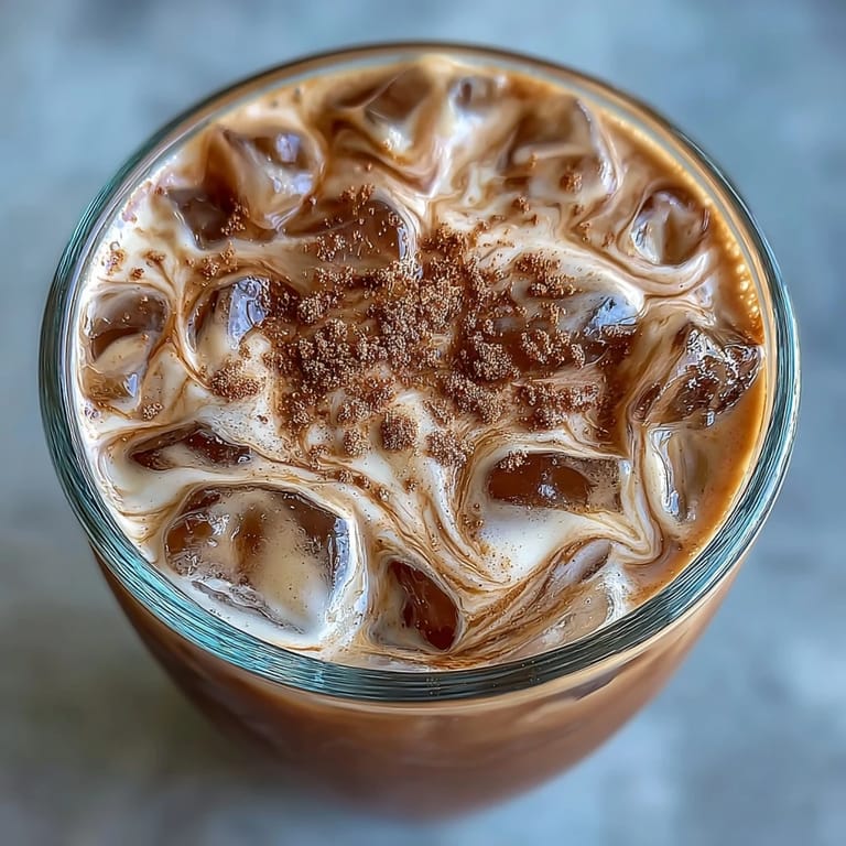 Creamy iced espresso with brown sugar syrup, oat milk, and a hint of cinnamon, served chilled.