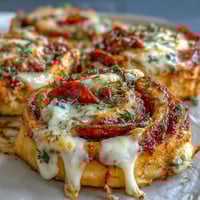 Savory pizza pinwheels with pepperoni and mozzarella, baked until golden and bubbling. Flaky pastry spirals make a perfect appetizer or party snack.